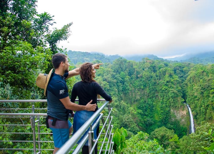 Pareja en el mirador de la Catarata Río Fortuna, con la caída de agua al fondo