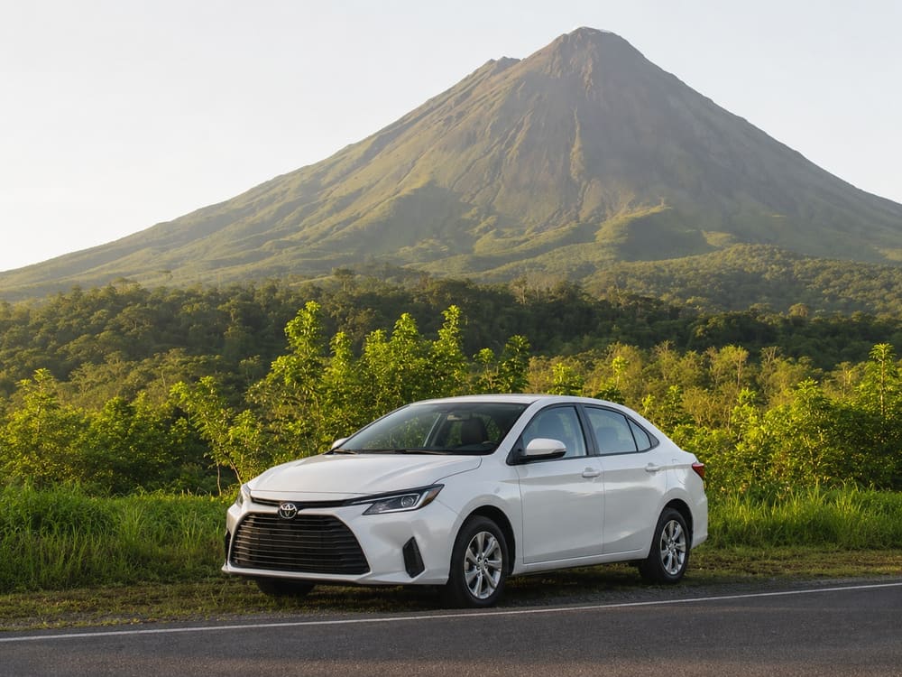 Vehículo sedán frente al Volcán Arenal, incluido en el Green Season Package