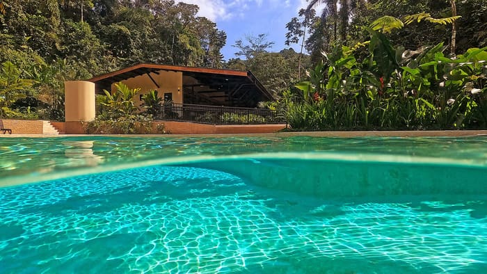 Piscina de aguas termales rodeada de vegetación junto al Río Tabacón